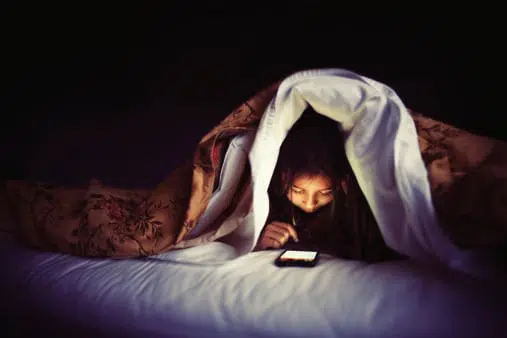 kid in bed with smartphone